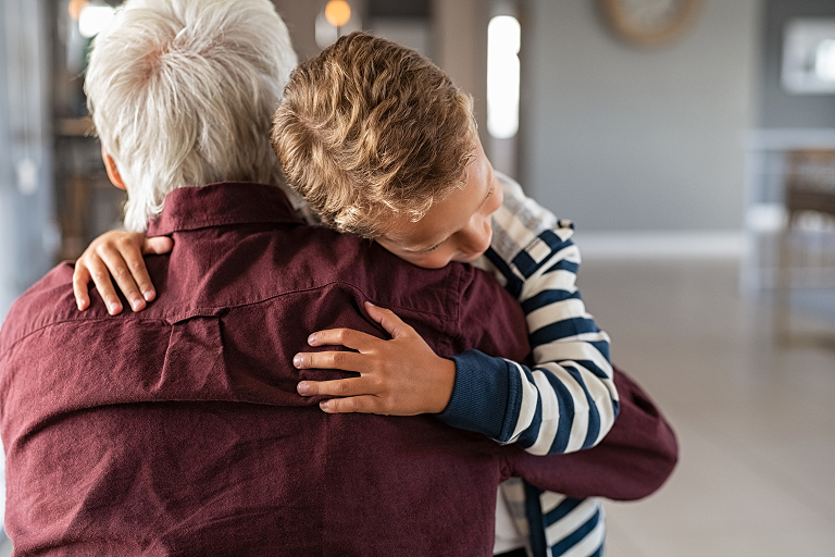 A young boy hugging his grandparent